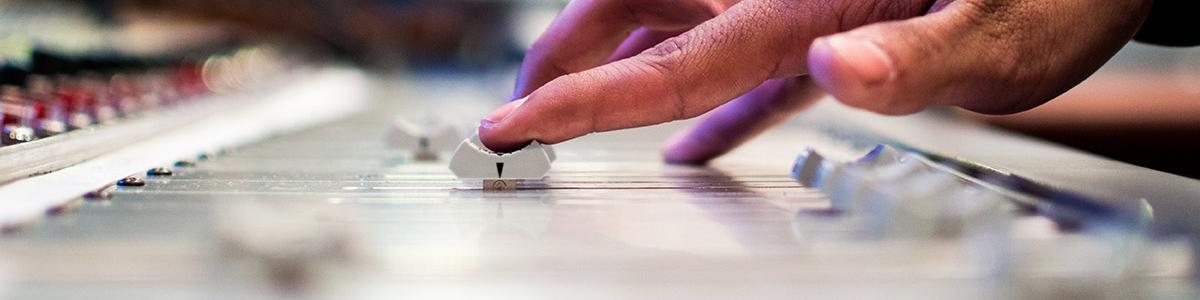 A student turns up the volume on a sound board